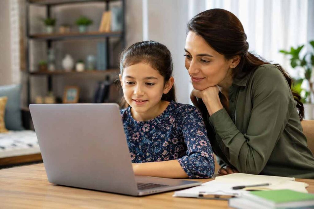 Mother and daughter looking at laptop together, discussing schools internet safety